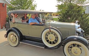 Four people inside a vintage car