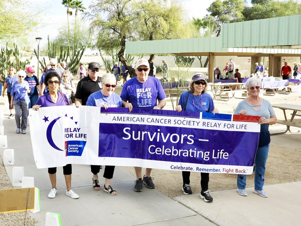 Members walking with a banner of the American Cancer Society Relay for Life, 2